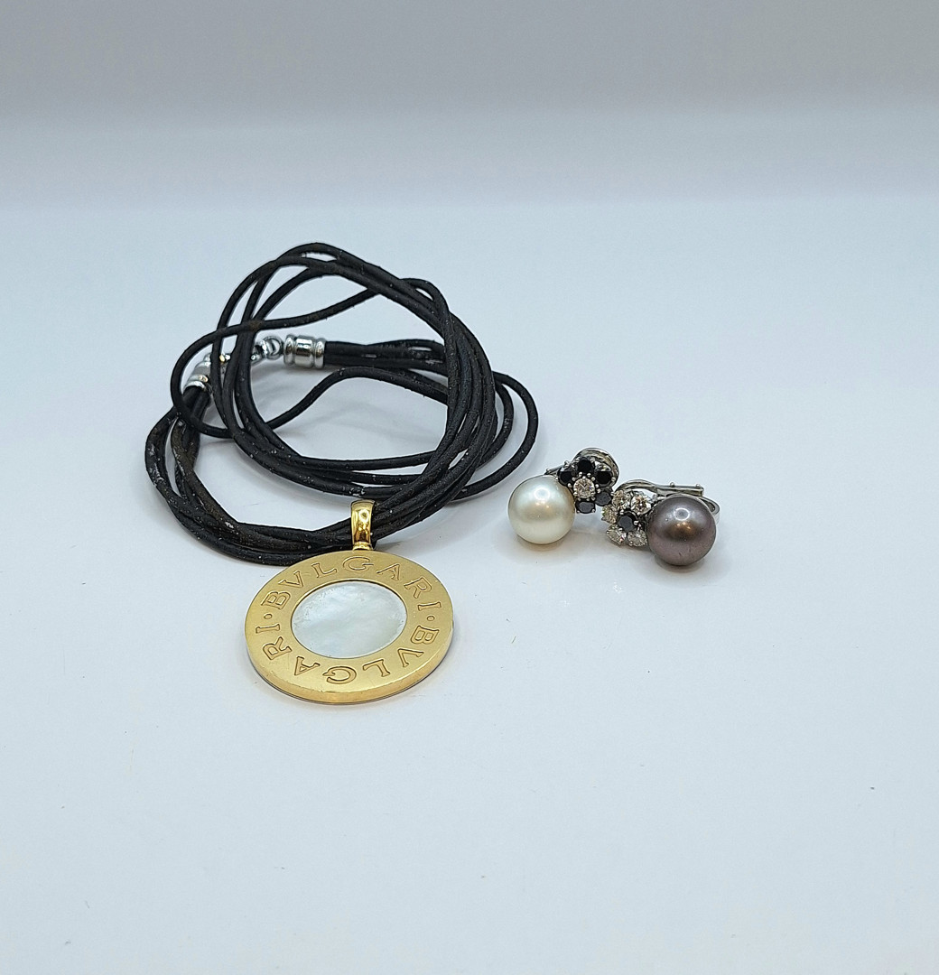 Un paio orecchini oro perle diamanti a firma Chantecler e laccio in cuoio con ciondolo acciaio e oro a firma Bulgari 