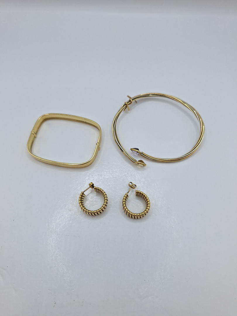 Due bracciali e un paio di orecchini in oro pietre