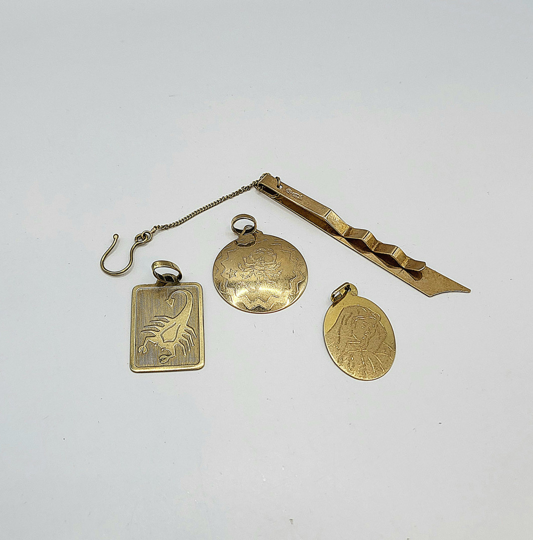 Tre ciondoli e fermacravatte oro 