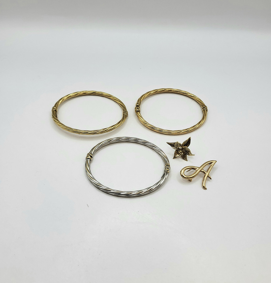 Tre bracciali e due spille oro 